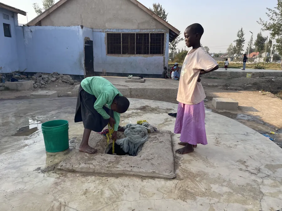Filling up at the well outside at Watoto Wa Africa