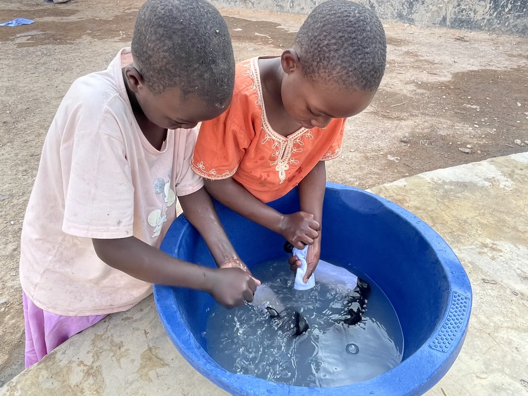 Washing clothes by hand at Watoto Wa Africa