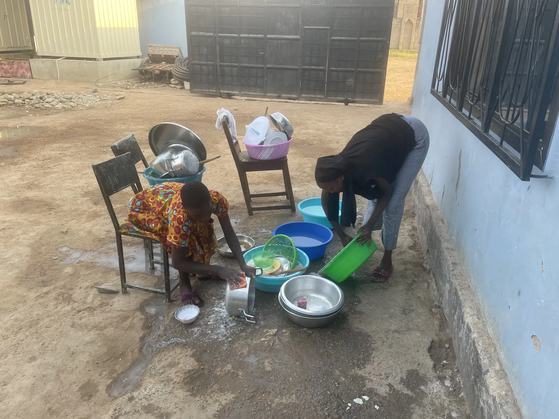 Washing dishes after a meal at Watoto Wa Africa