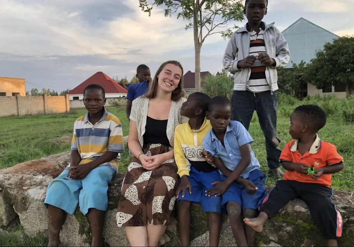 A past volunteer with children at Watoto Wa Africa