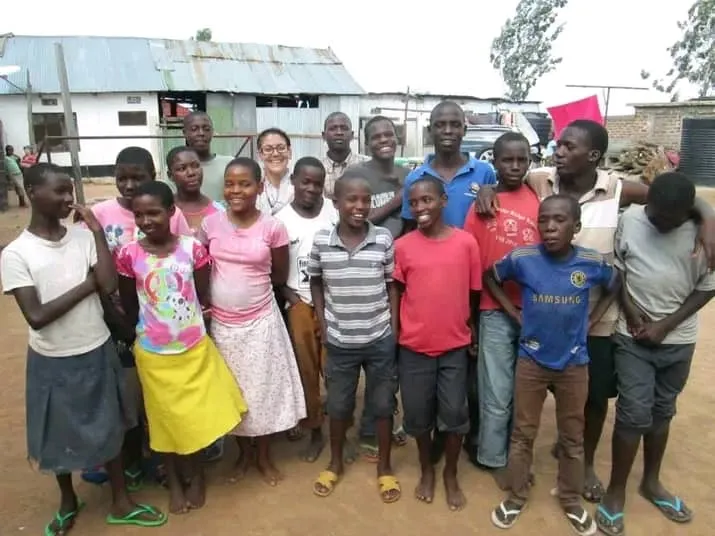 A past volunteer with children at Watoto Wa Africa