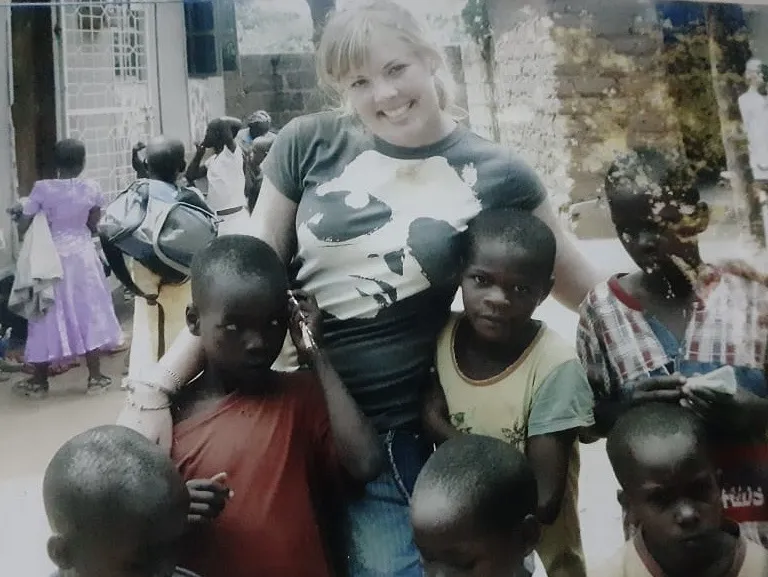A past volunteer with children at Watoto Wa Africa